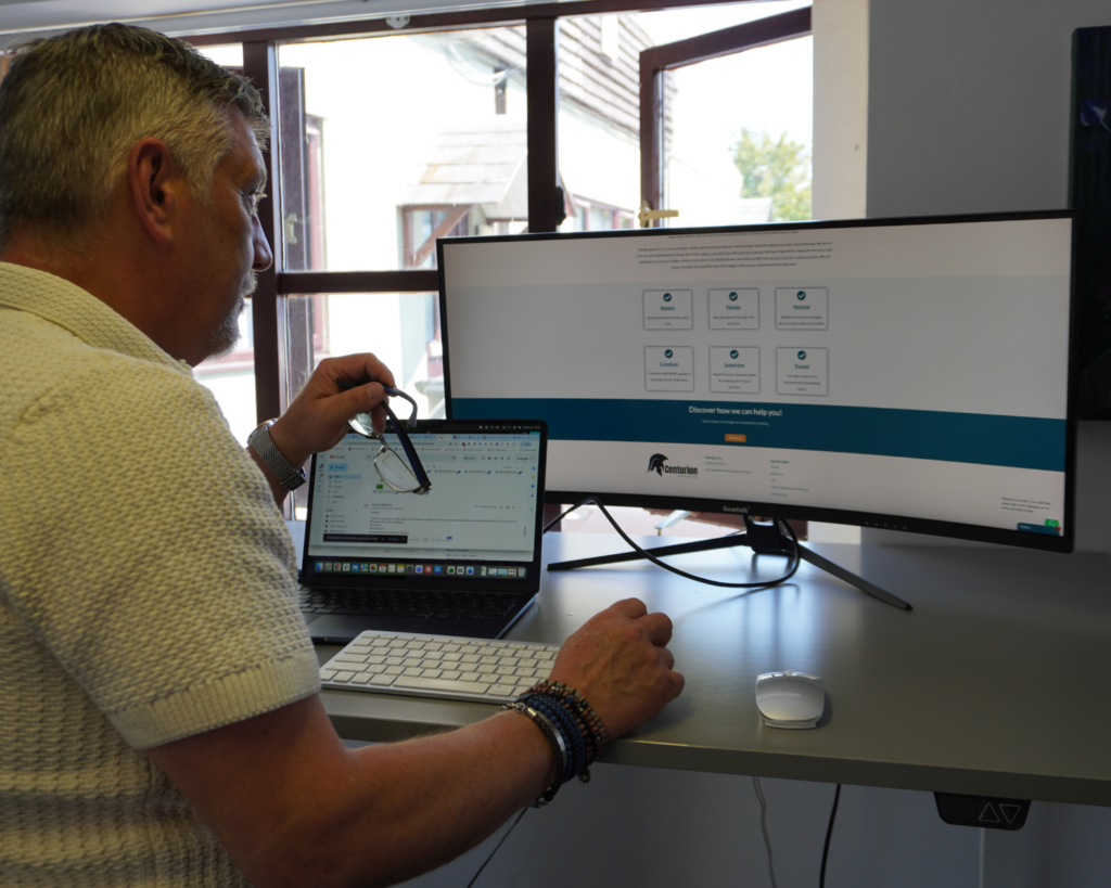 Managing Director Dave Davis working at desk showing the Centurion Payroll website